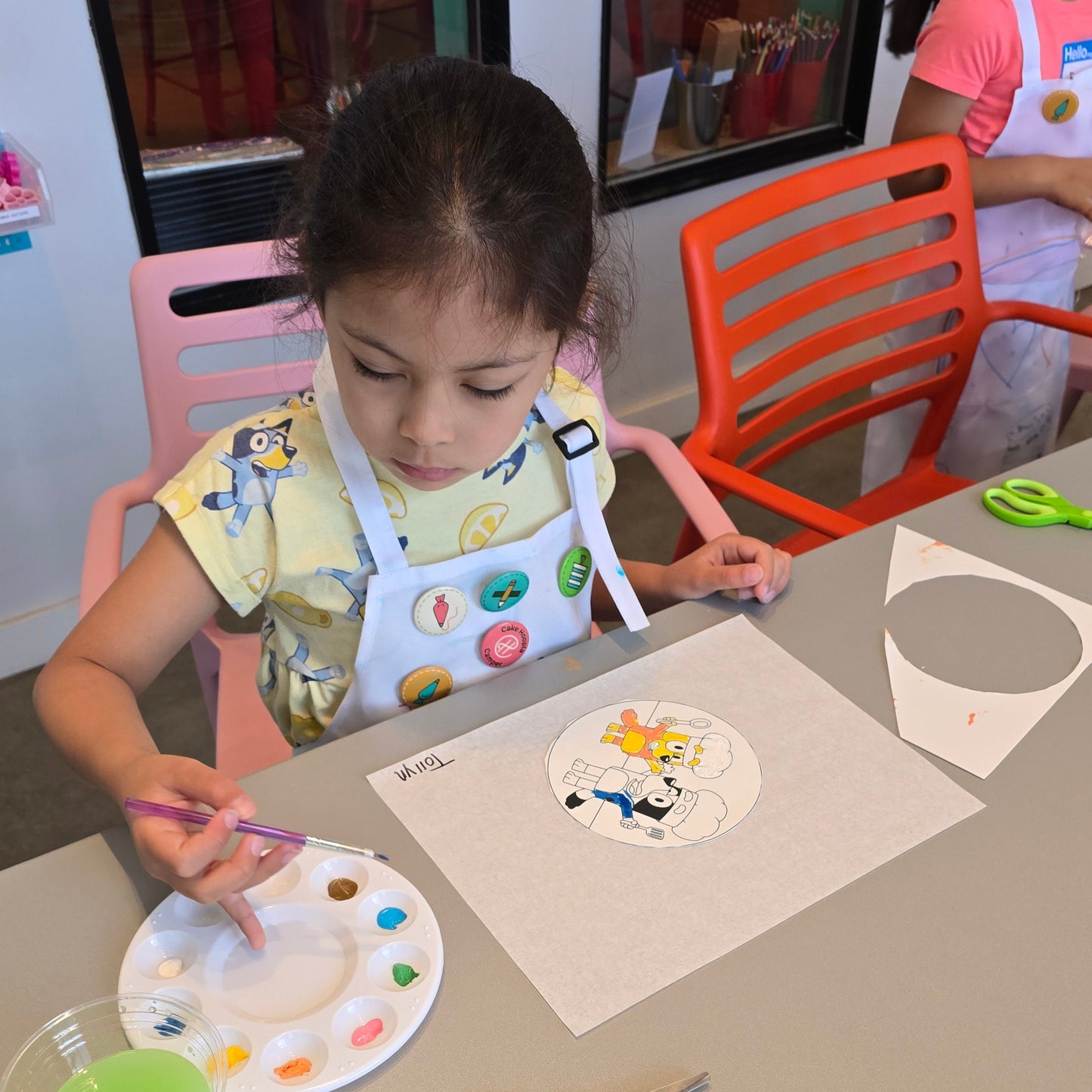 Girl paints frosting craft project at Cake Hoopla during cake camp.
