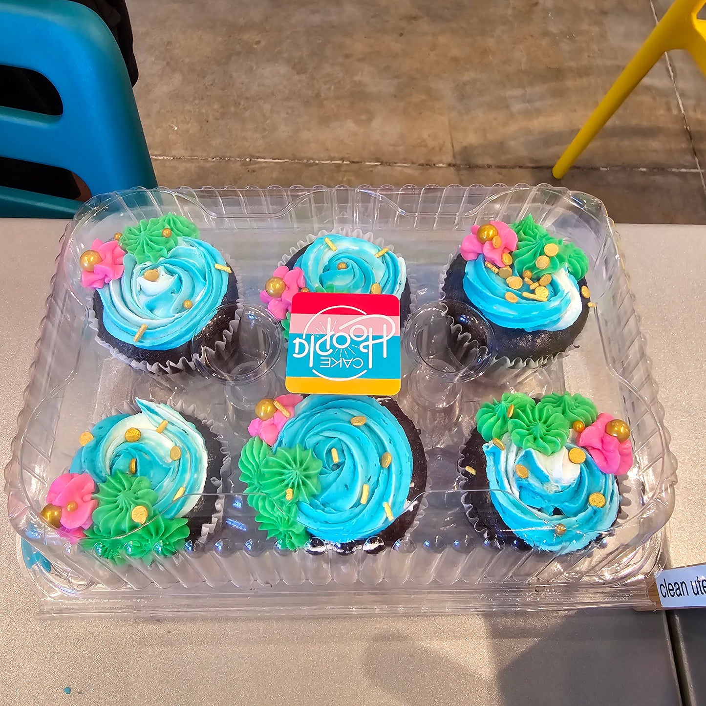 Cupcakes decorated white, blue, green, and pink with flowers, swirls, and gold sprinkles from the Create Your Own Cupcake Kit available during time or as a to-go kit from Cake Hoopla in Tigard, Oregon near Portland.