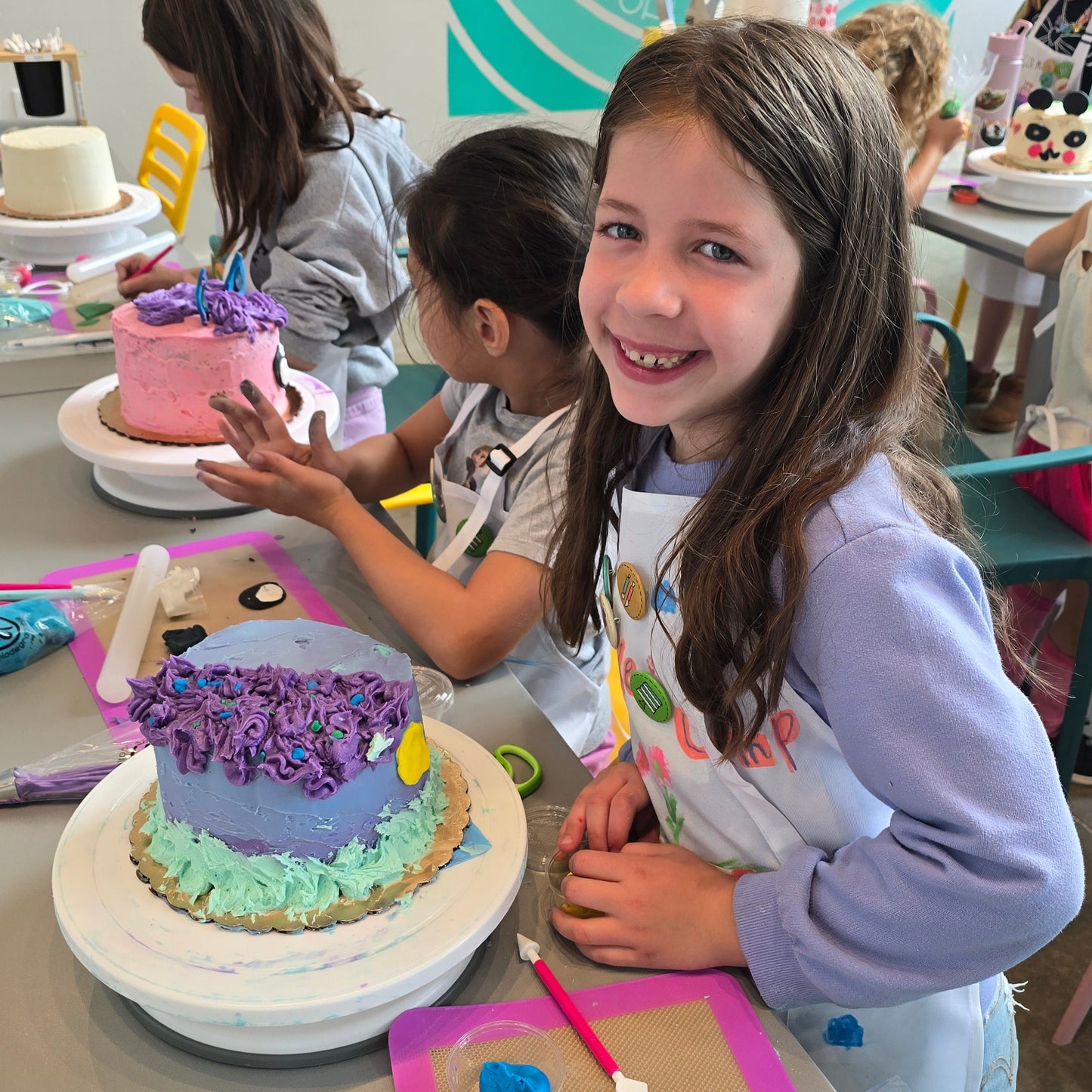 Kids decorate their custom cakes designed during cake camp at Cake Hoopla in Tigard near Portland.
