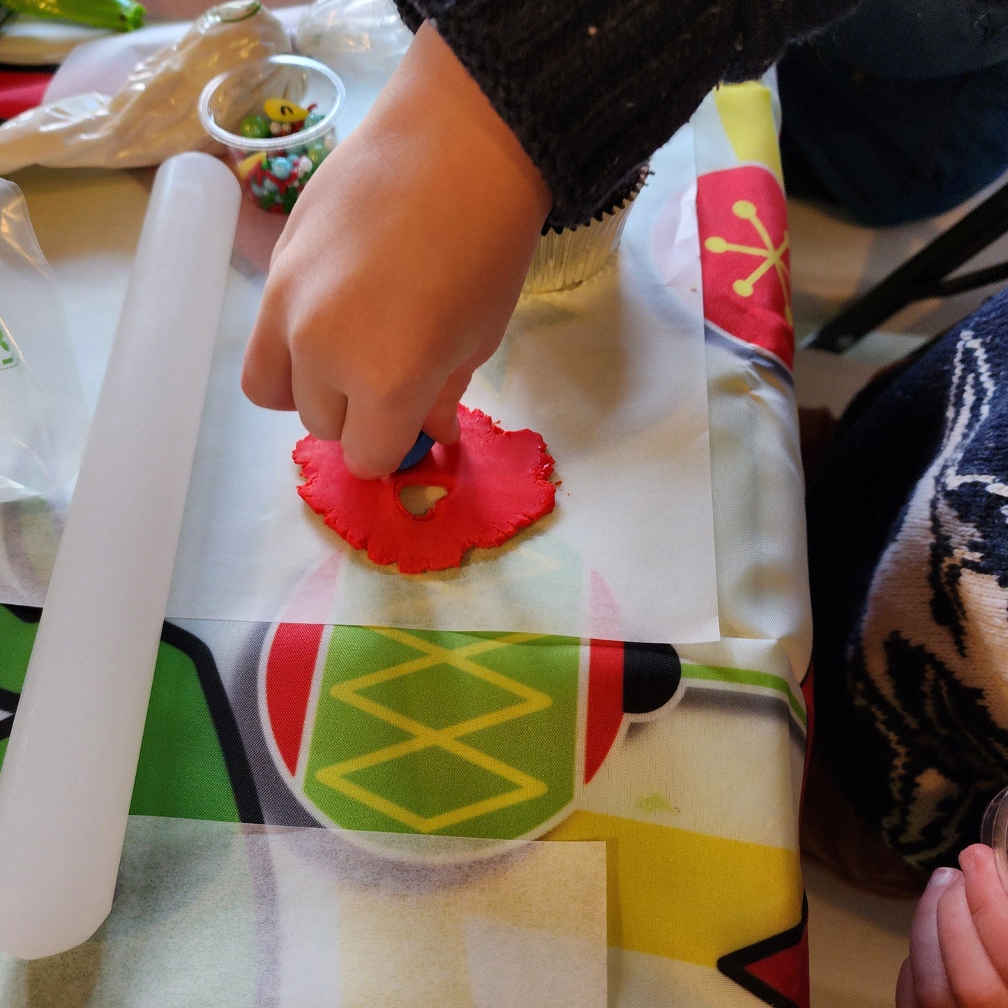 A small kid cuts a fondant shape to add to a cupcake at a to-go DIY cupcake-decorating party by Cake Hoopla, in Tigard near Portland.
