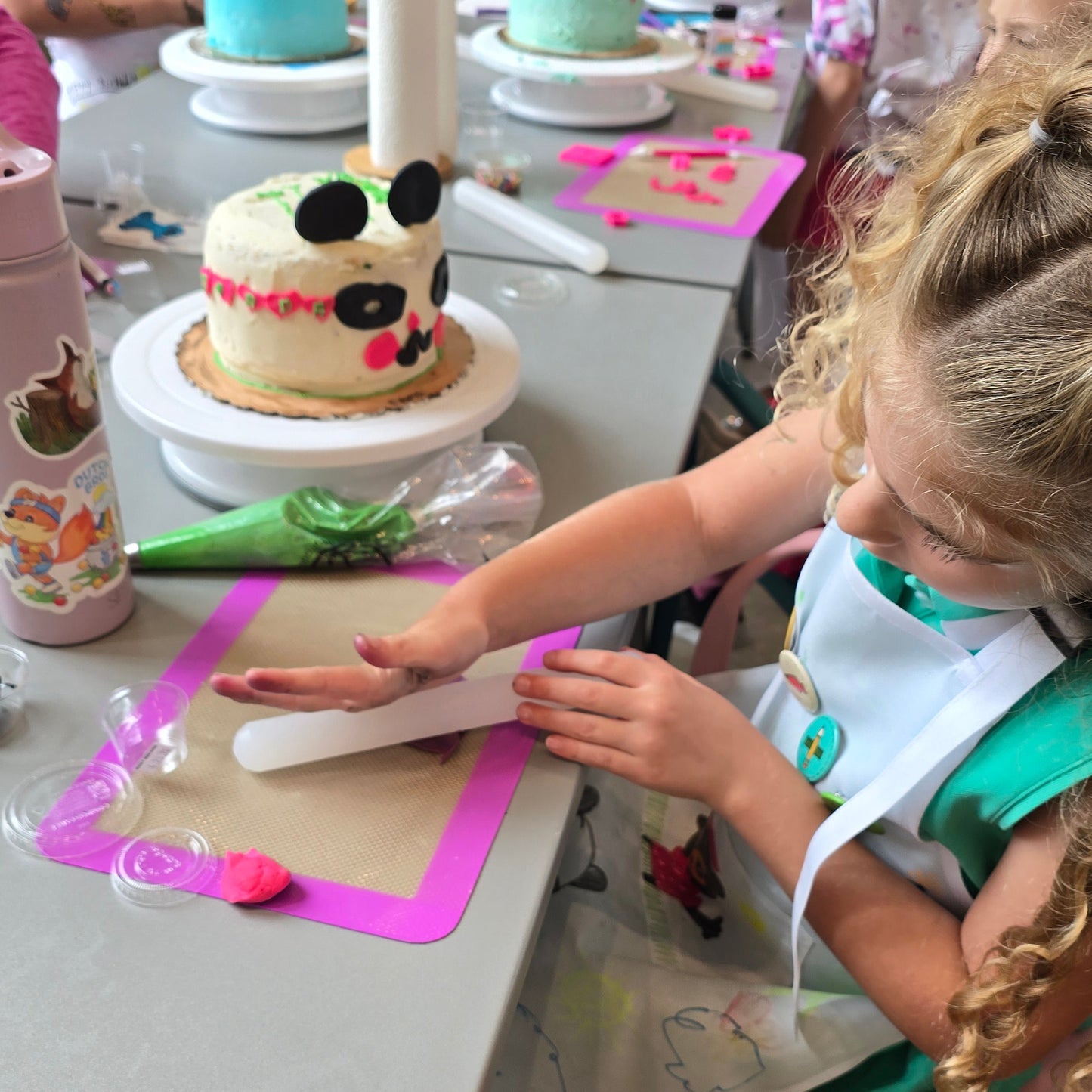 Girl decorates her custom panda cake at Cake Hoopla's cake camp in Tigard near Portland.