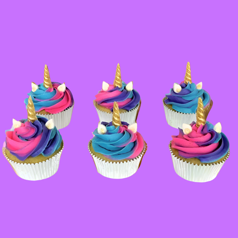Finished unicorn-themed cupcakes from the Myth Makers cupcake kit. Pink, purple and blue frosting topped with gold-painted unicorn horns, available during open studio time or for pickup at Cake Hoopla in Tigard, near Portland.