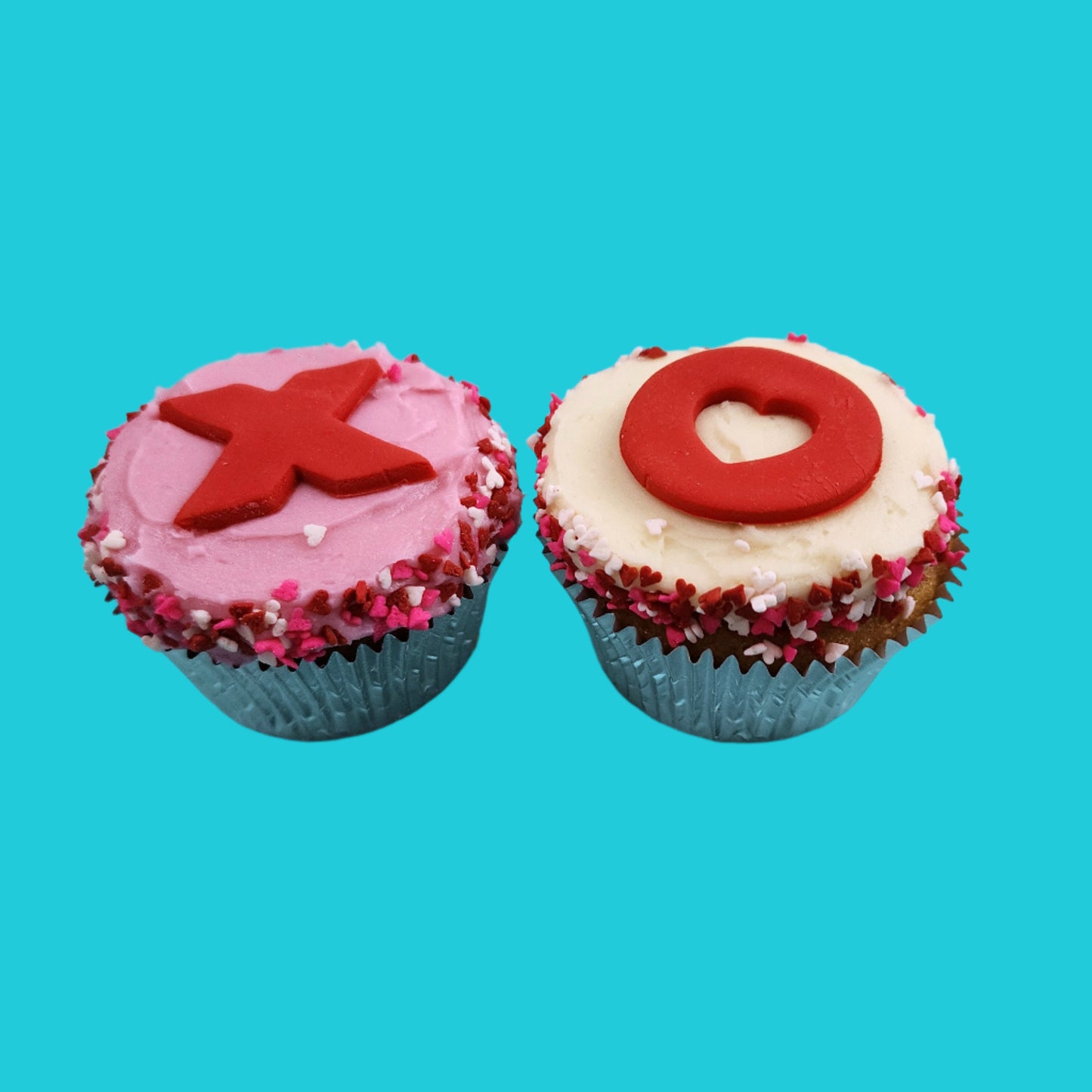 Cupcakes frosted pink and white with red and pink Xs and Os, hearts, and sprinkles from the Hugs, Kisses, Cupcakes DIY cupcake-decorating kit available during open studio time, to-go, or ready-to-serve cupcakes from Cake Hoopla in Tigard, Oregon near Portland.