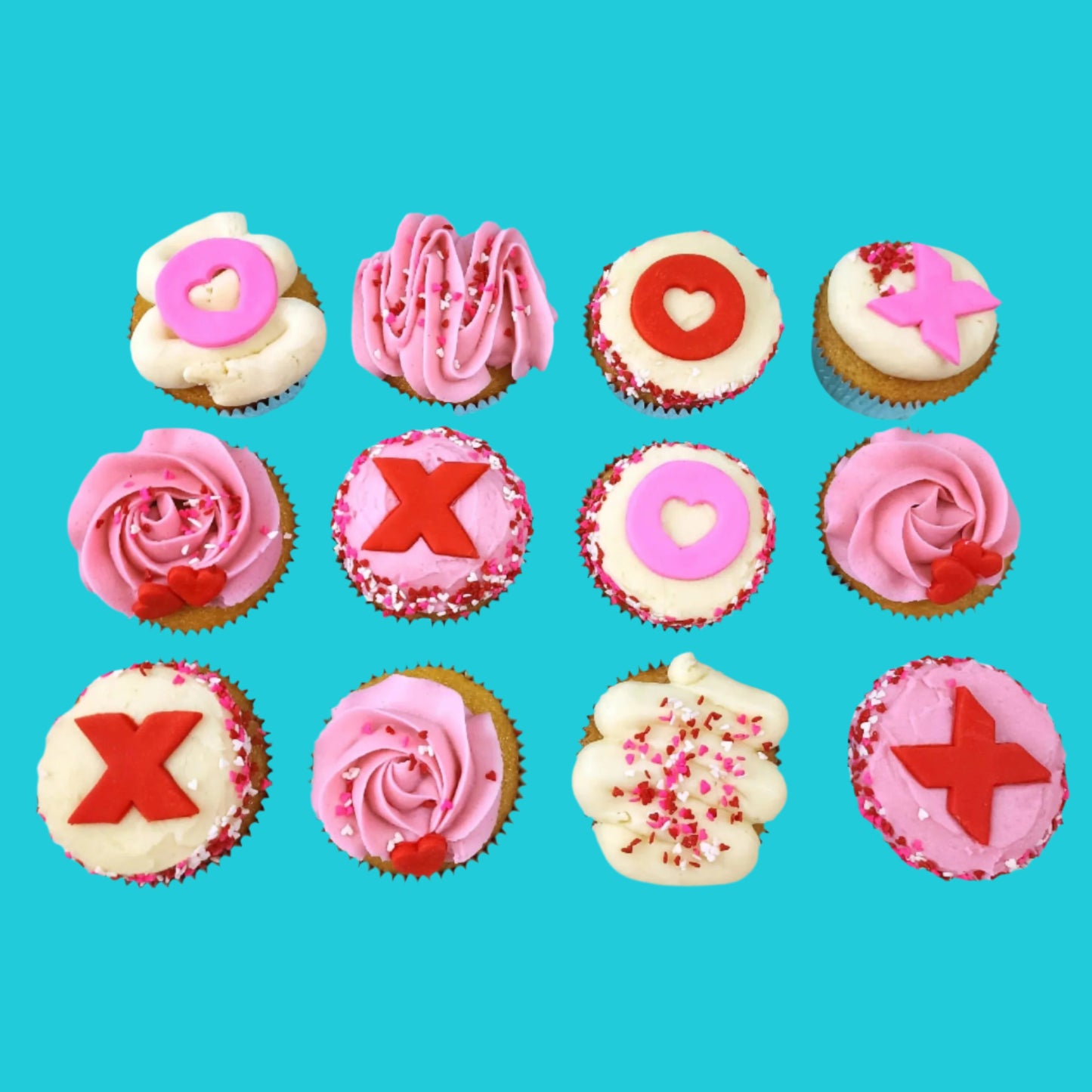 Cupcakes frosted pink and white with red and pink Xs and Os, hearts, and sprinkles from the Hugs, Kisses, Cupcakes DIY cupcake-decorating kit available during open studio time, to-go, or as pre-decorated cupcakes from Cake Hoopla in Tigard, Oregon near Portland.