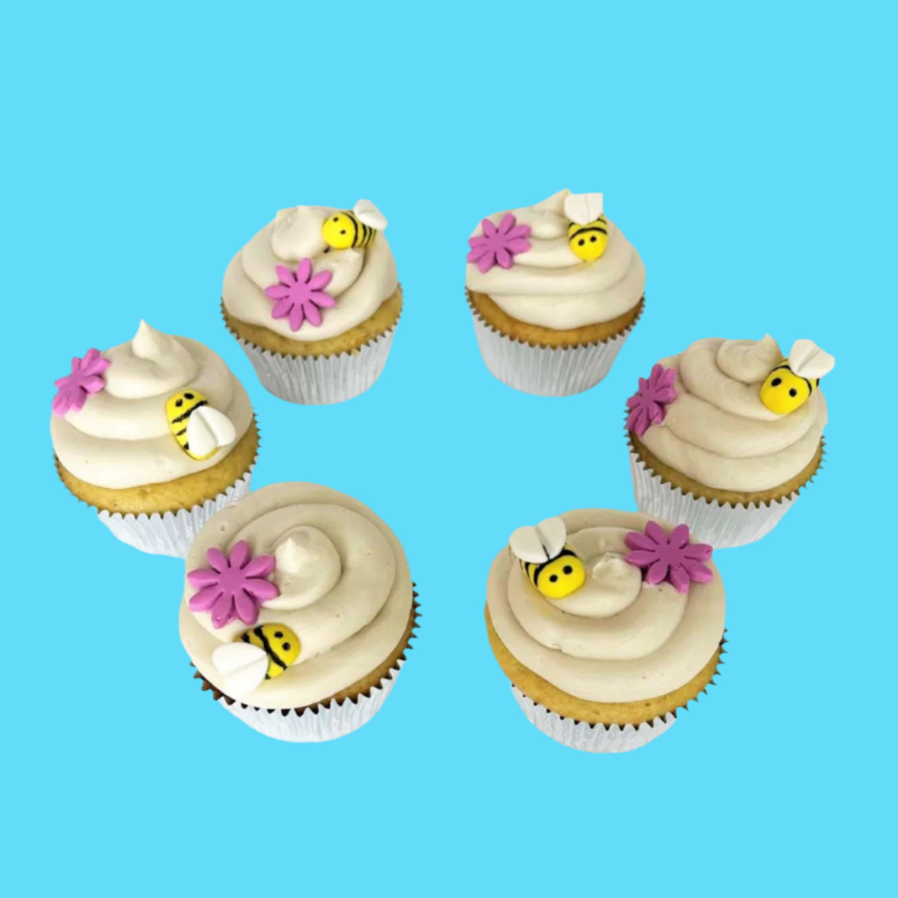 Bee-themed cupcakes frosted in white with yellow and black bumble bees and pink flowers on top; pre-decorated cupcakes shipped to the continental US.