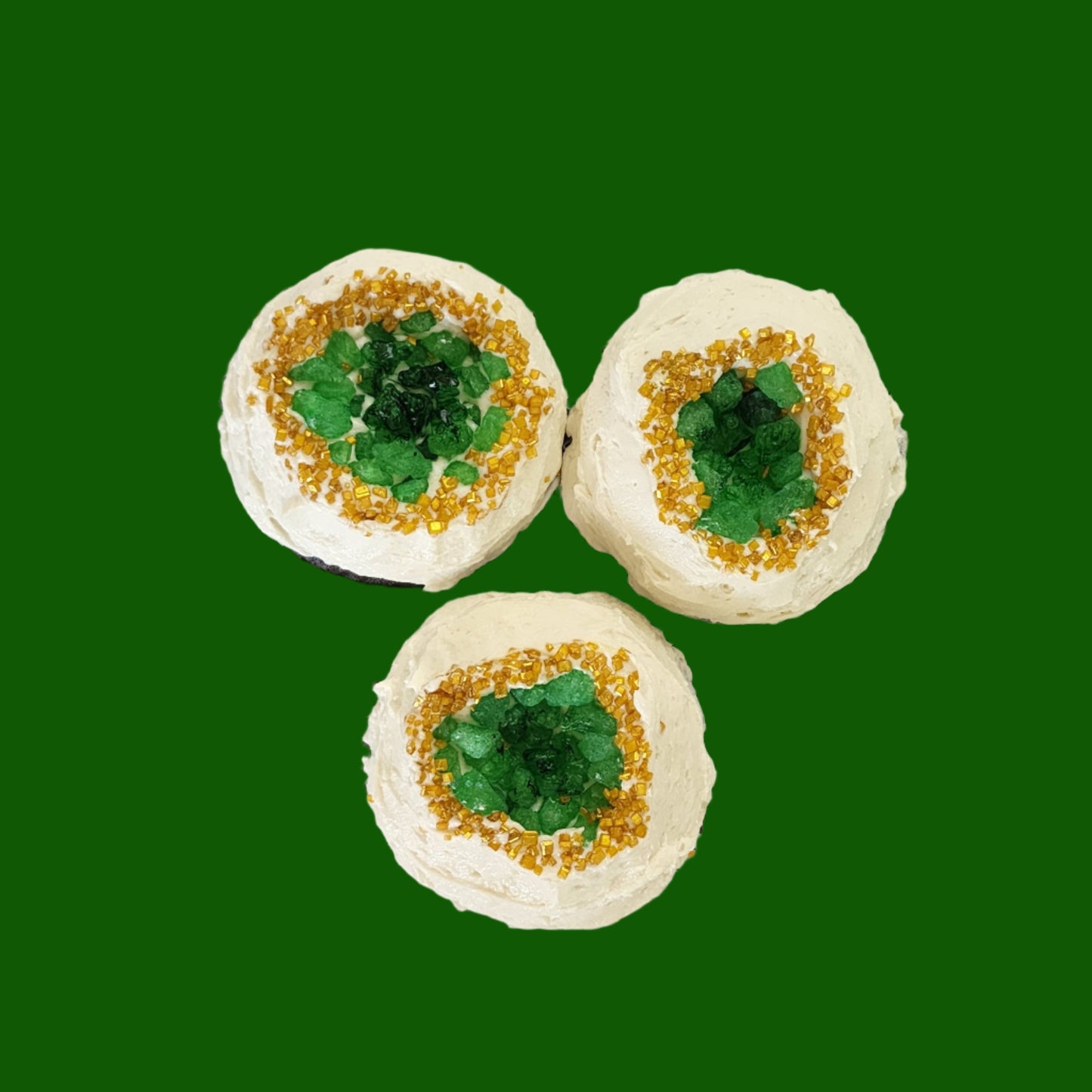 Geode cupcakes frosted white with green candy gems in the middle surrounded by gold sprinkles; pre-decorated cupcakes available for shipping to the continental US.
