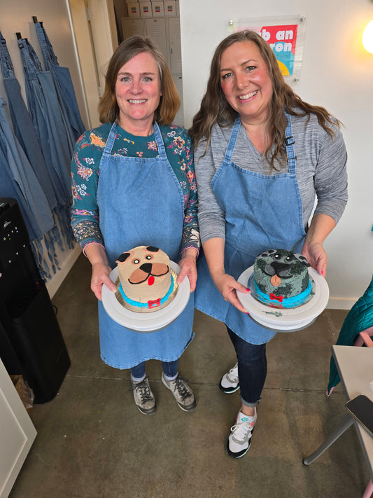 Two women show off their dog cakes created during a Cake Hoopla cake decorating class in the Portland area.