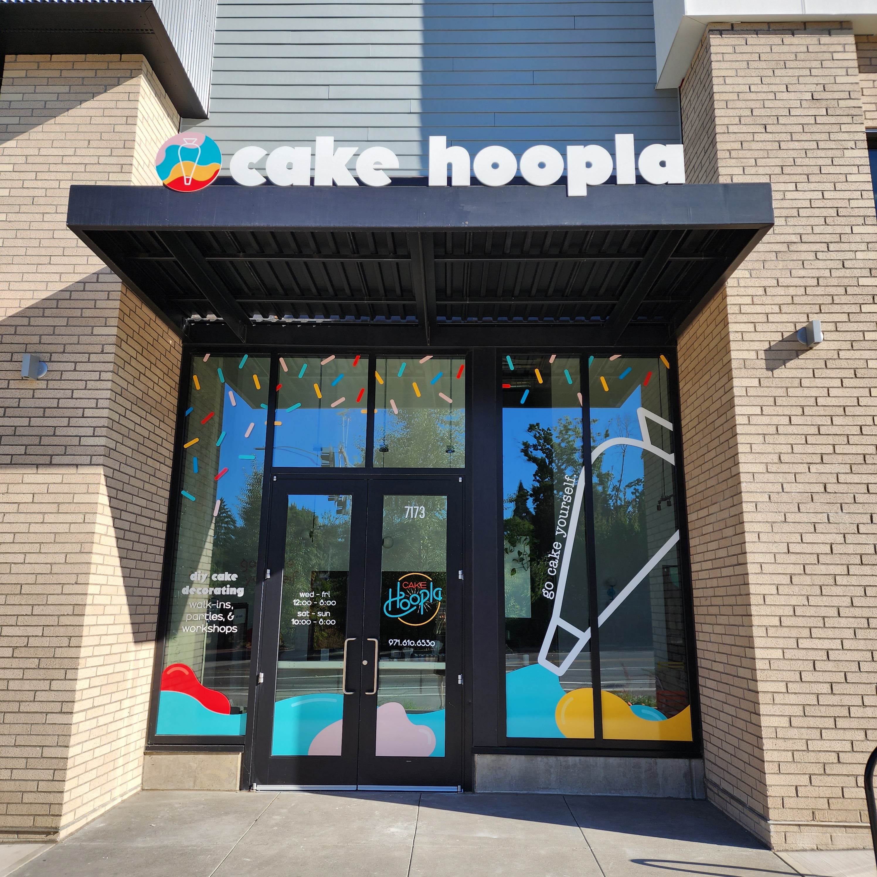 Exterior view of Cake Hoopla in Tigard, near Portland, with bright fun colors and DIY cake-decorating written in branding.