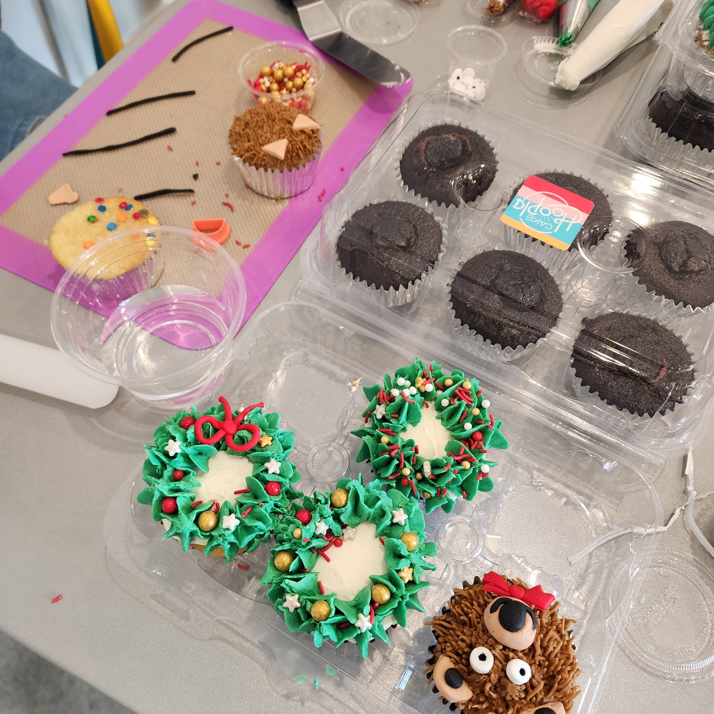 Cupcakes decorated like teddy bears and Christmas wreaths during a holiday DIY cupcake-decorating class at Cake Hoopla in Tigard, Oregon near Portland.