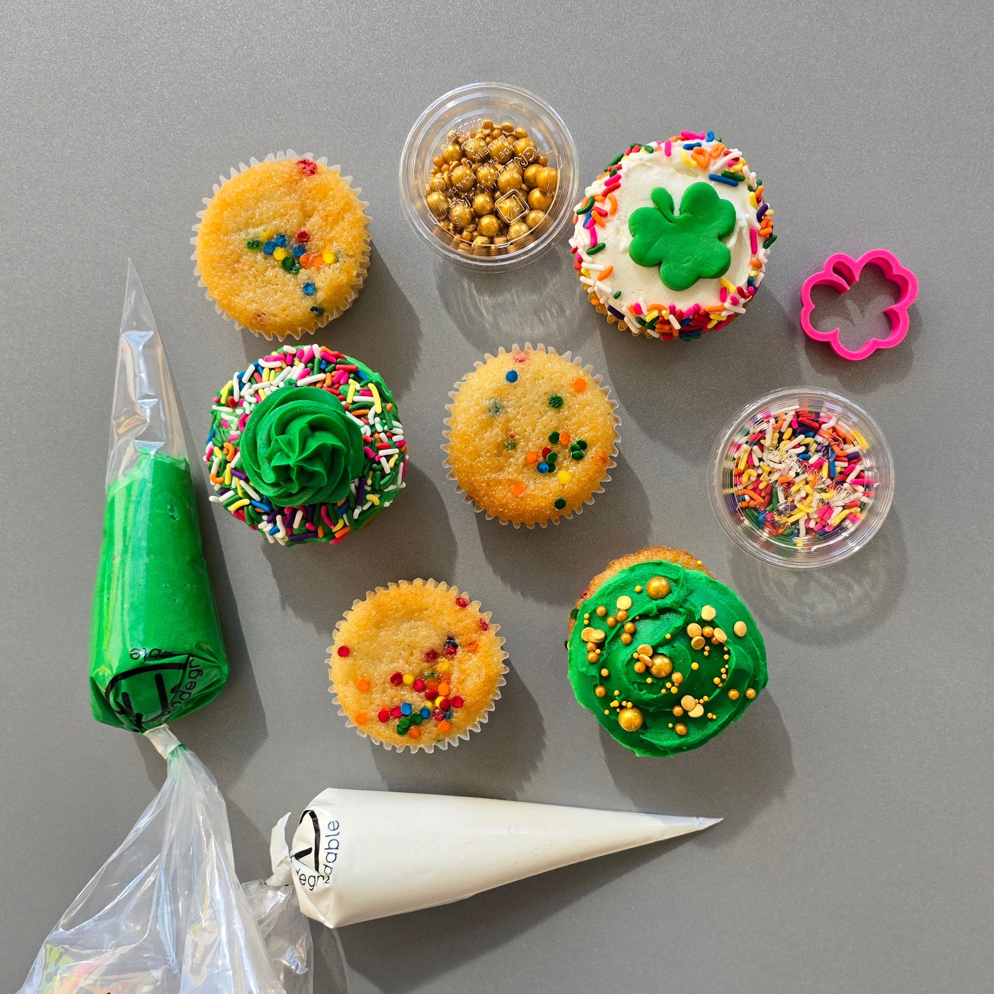 St. Patrick Day themed cupcake kit with white and green frosting, gold and rainbow sprinkles, green fondant, and a shamrock fondant cutter, available at Cake Hoopla in Tigard, Oregon near Portland, during open studio time for DIY cupcake decorating.