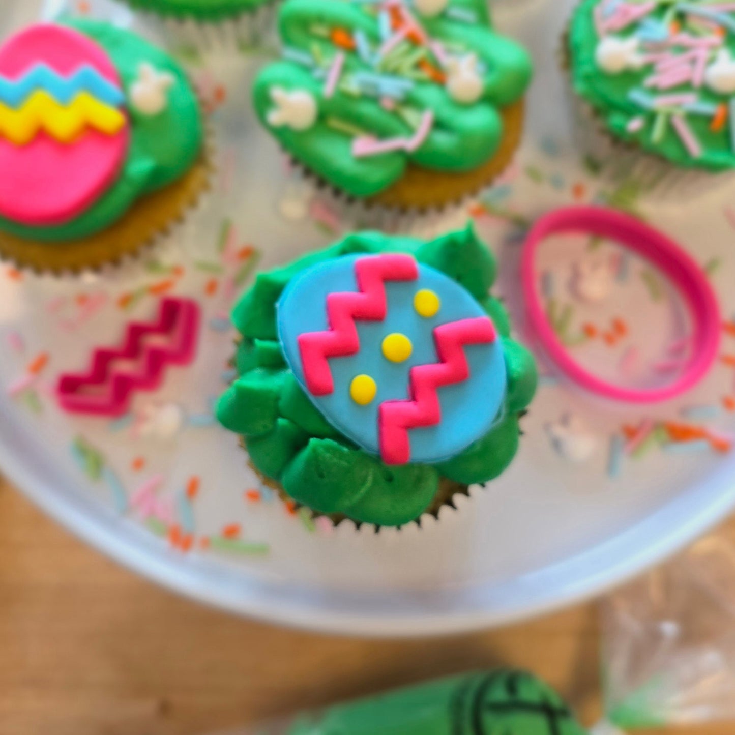 Bright, springtime DIY cupcake-decorating kit with Easter eggs made of fondant, pink, blue, and yellow fondant, fondant cutters, and a bunny sprinkle mix, available during open studio time at Cake Hoopla in Tigard, OR near Portland.