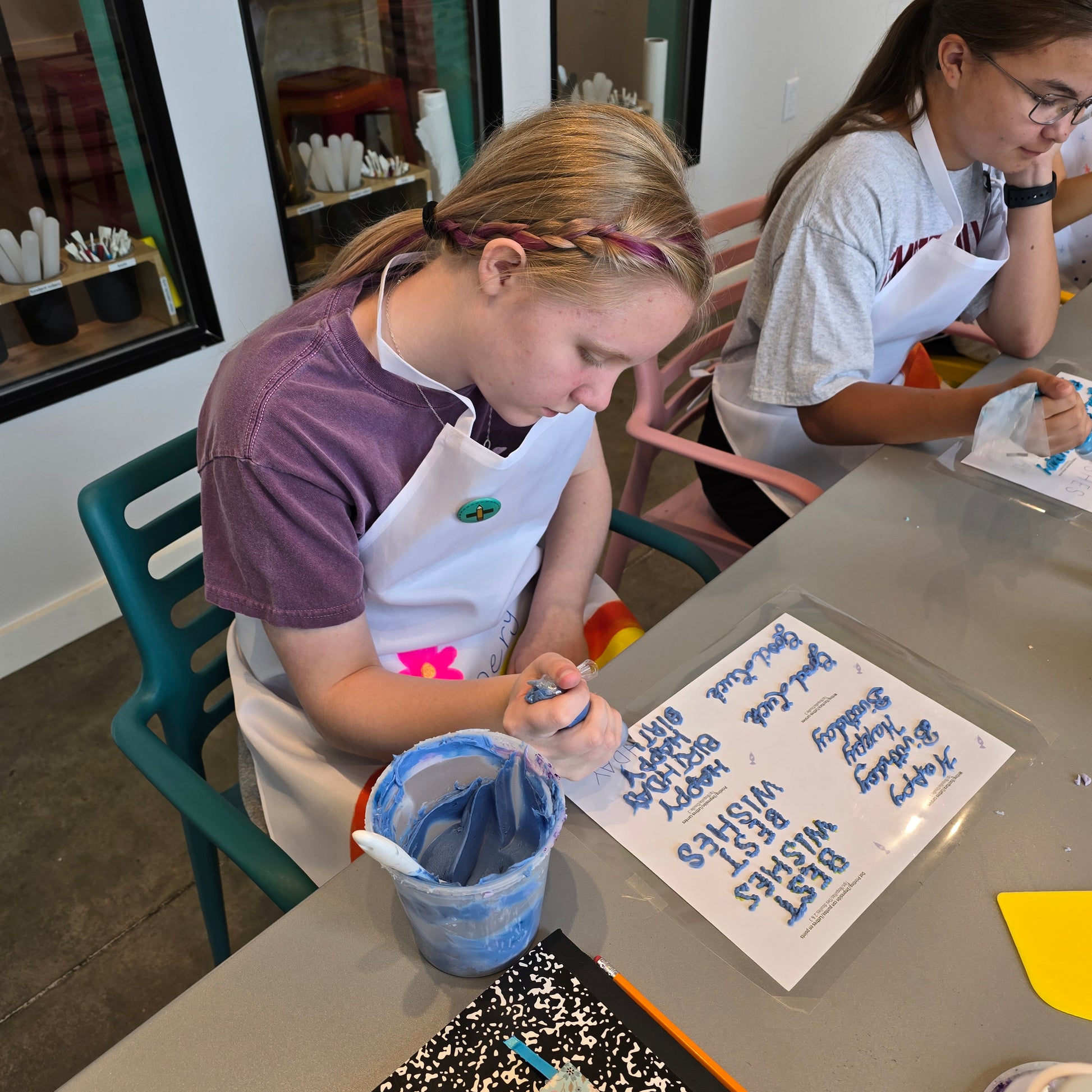 A girl practices writing with frosting during a cake-decorating lesson at Cake Hoopla in Tigard, Oregon, near Portland.