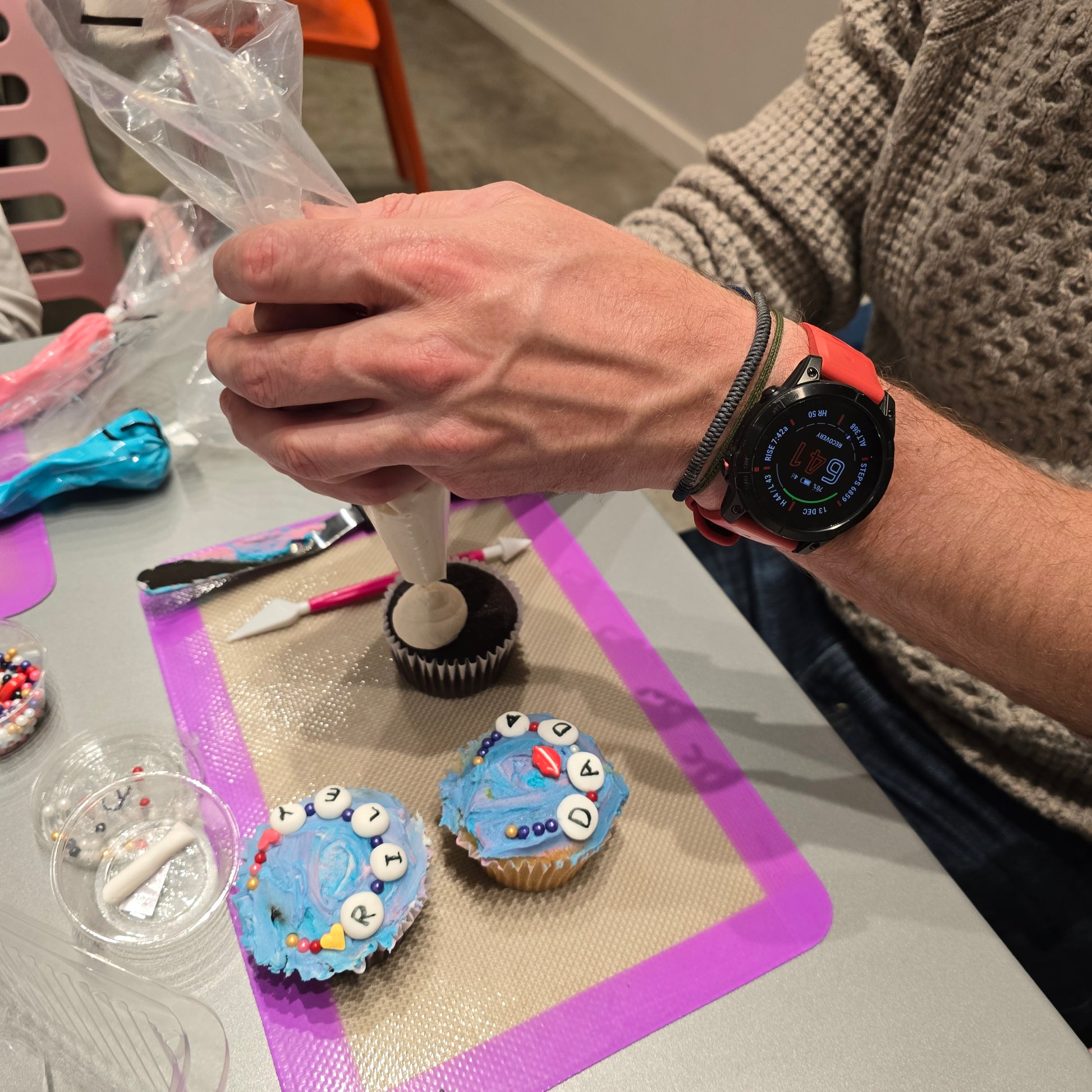 A Cake Hoopla customer in Tigard, Oregon, near Portland, decorates DIY Swiftie-themed Friendship Bracelet Cupcakes during open studio time.