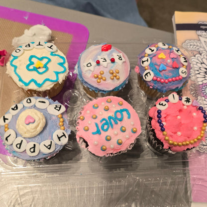 A Cake Hoopla customer's DIY Swiftie-themed Friendship Bracelet cupcakes, one decorated saying "Swiftie," "Happy Birthday," and more, created during open studio time in Tigard, Oregon, near Portland.