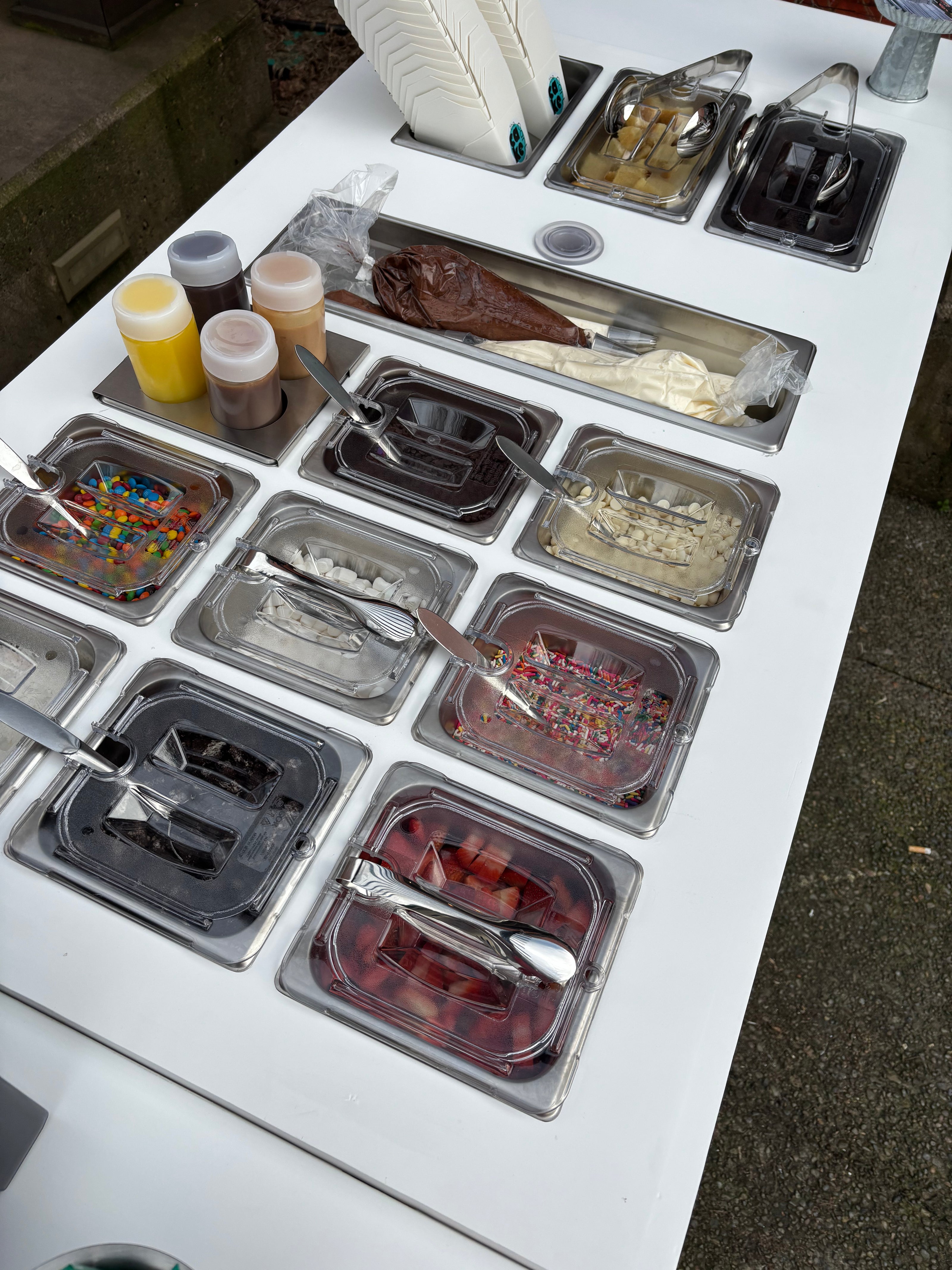Cake Hoopla's mobile dessert cart set up for an event in the Portland area with cake, fun toppings, and yummy drizzles.