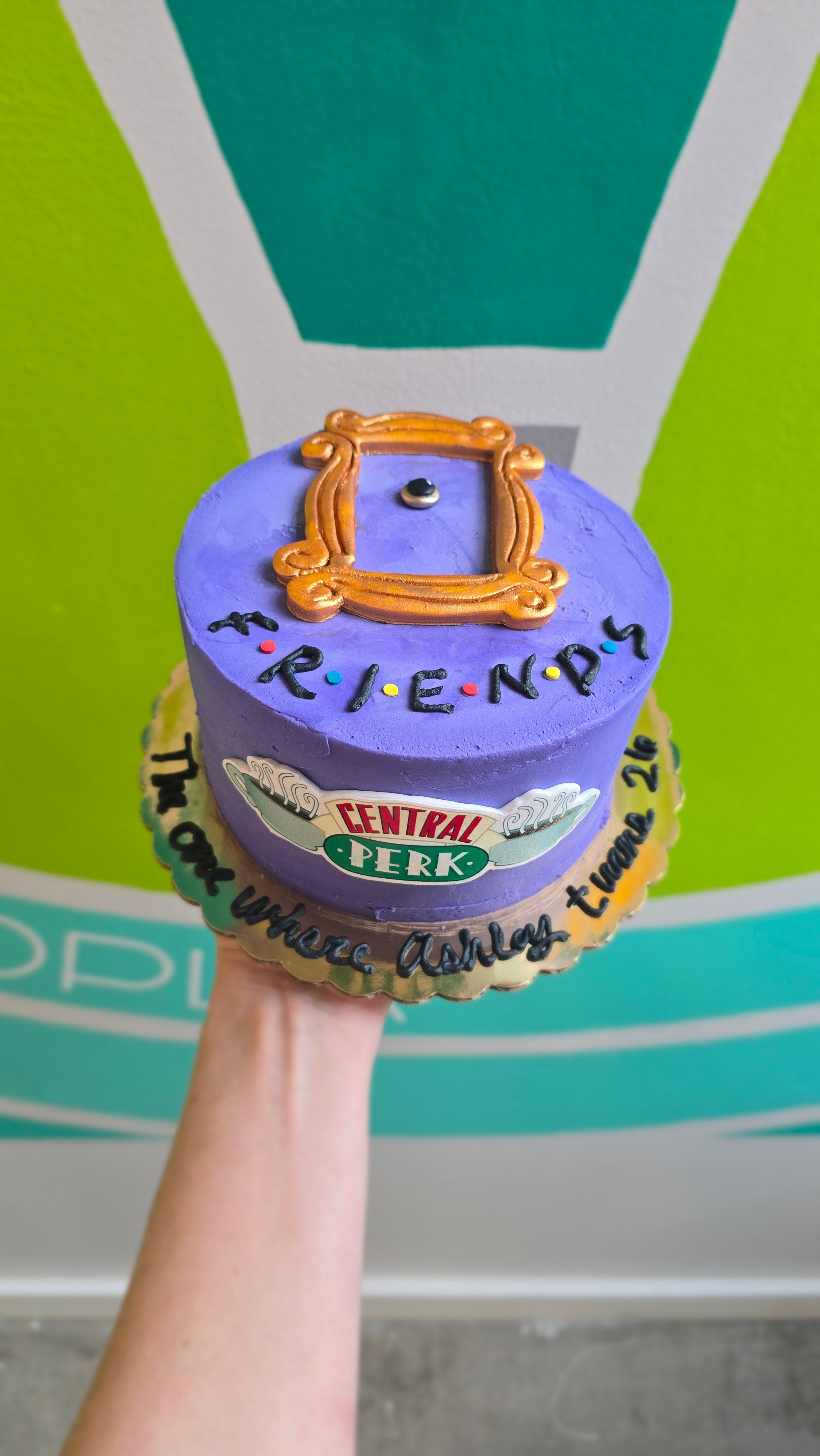 Purple Friends cake with Central Perk applique and gold picture from from Monica's apartment door.