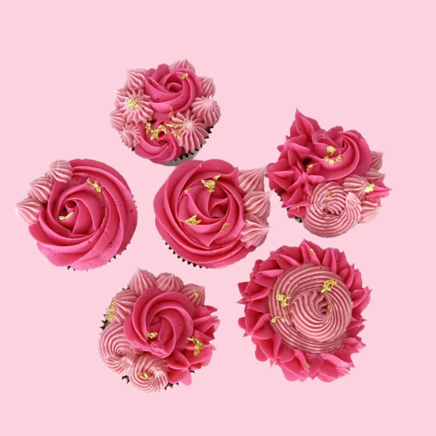 Finished cupcakes from the La Fleur DIY cupcake-decorating frosted with bright pink and light pink rosettes, pointy stars, and little swirls. Small amounts of gold leaf highlight each cupcake. Available as a DIY cupcake kit during open studio time and to go and as ready-to-serve cupcakes from Cake Hoopla in Tigard, Oregon near Portland.