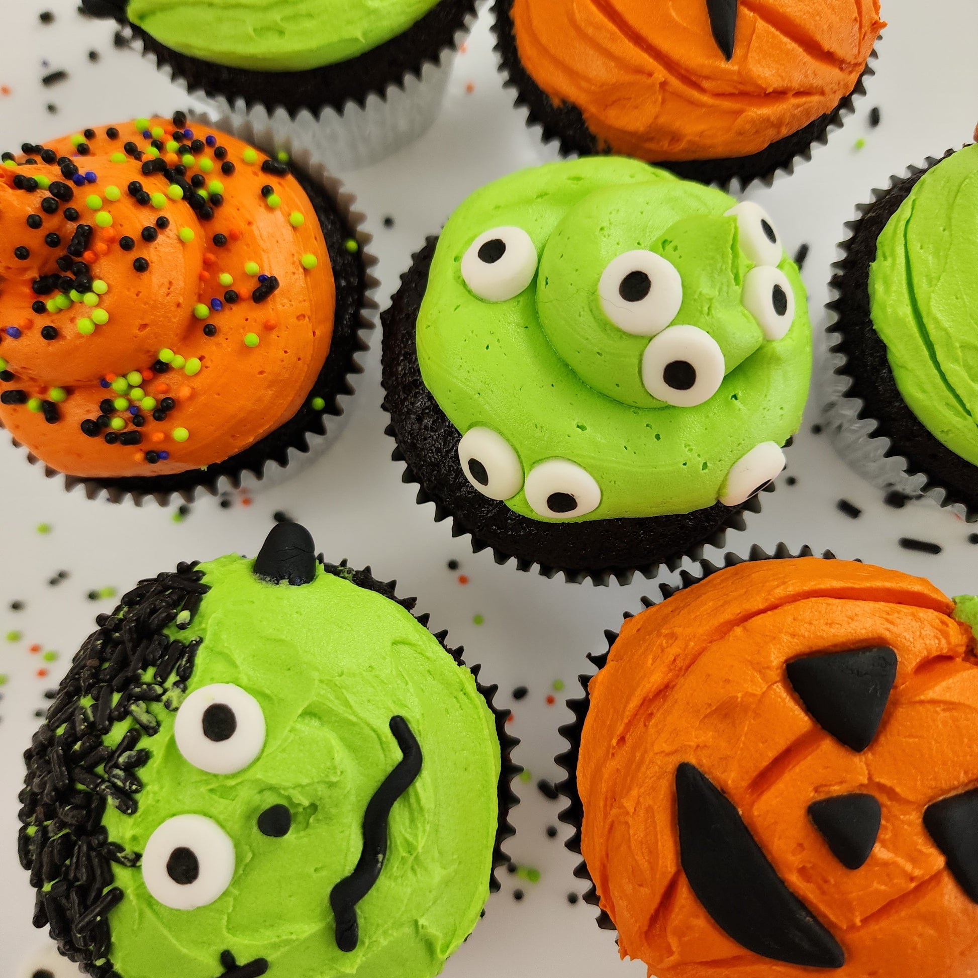 Halloween-themed cupcakes with Frankenstein, jack o'lanterns, pumpklins, and Halloween sprinkles available for pickup at Cake Hoopla in the Portland area.