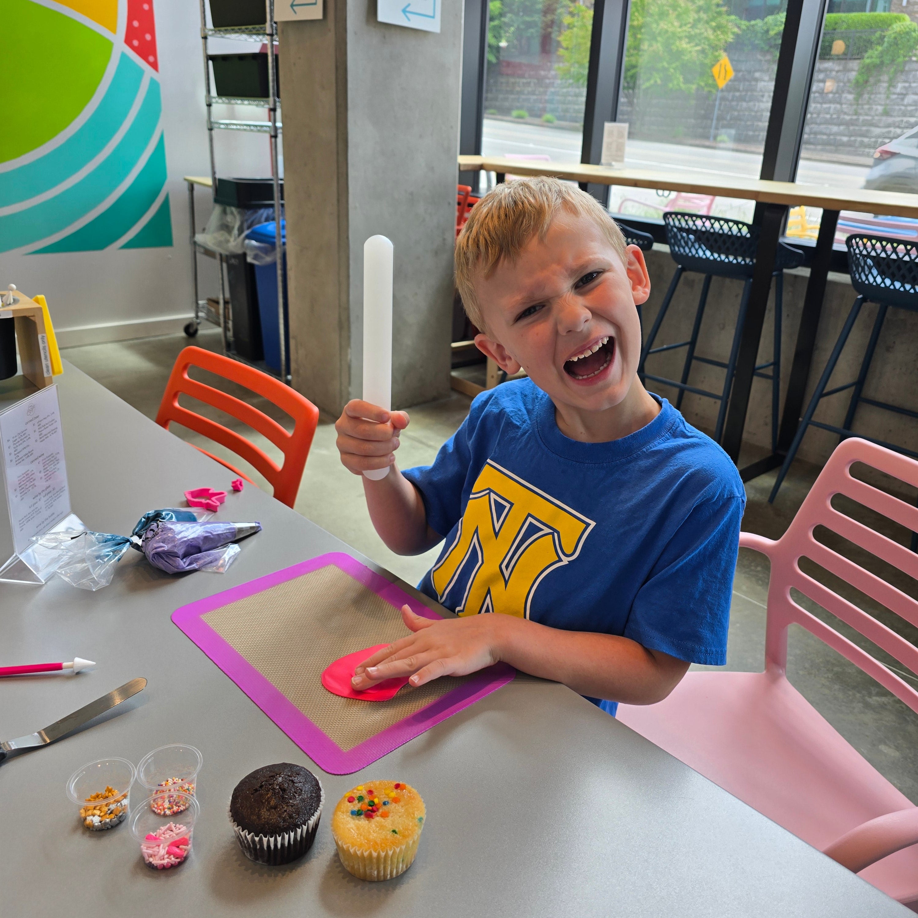 A kindergartener plays with fondant and tools as he decorates cupcakes during open studio time at Cake Hoopla in Tigard near Portland.