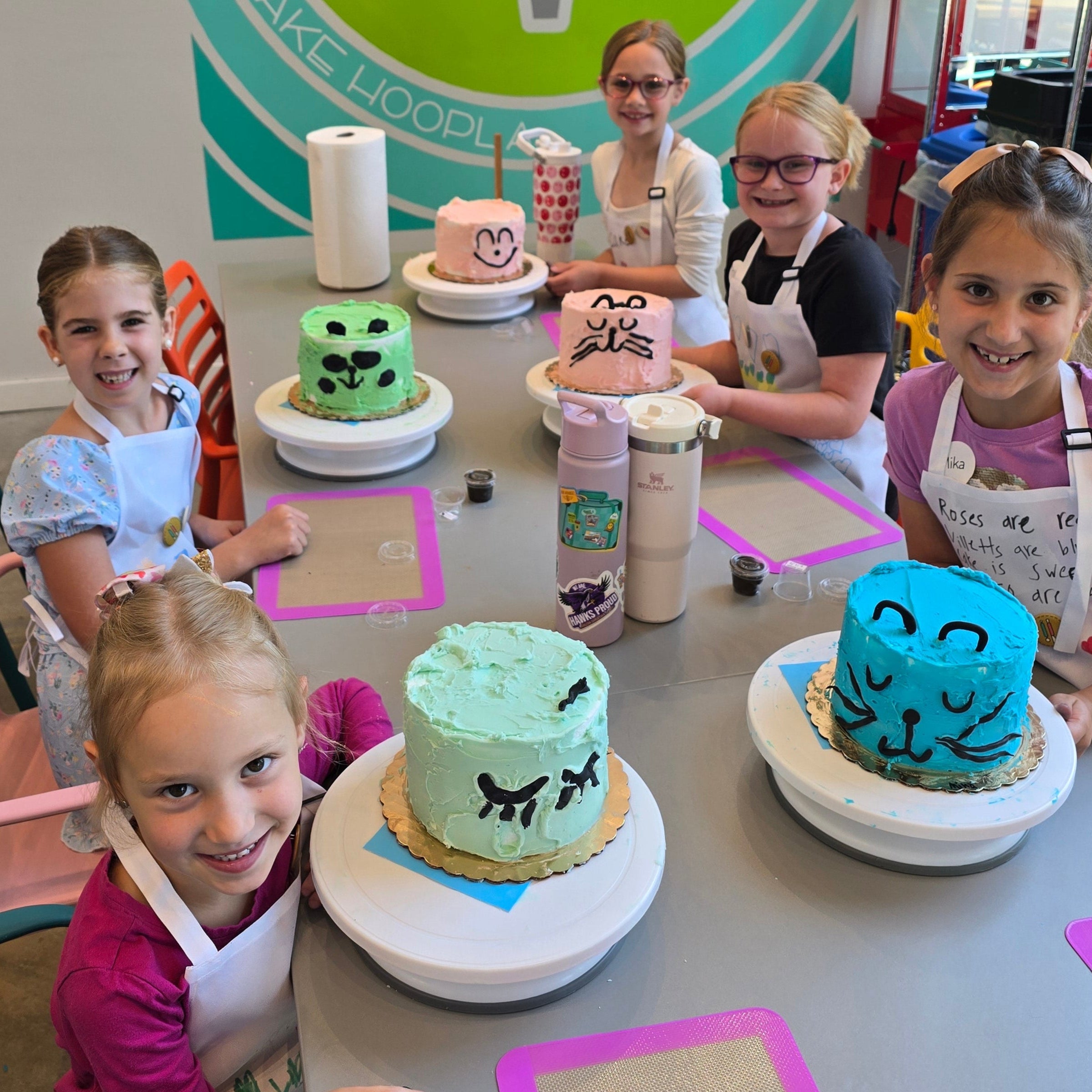 Kids around a table at Cake Hoopla in Tigard, near Portland, decorating cakes to look like cats.