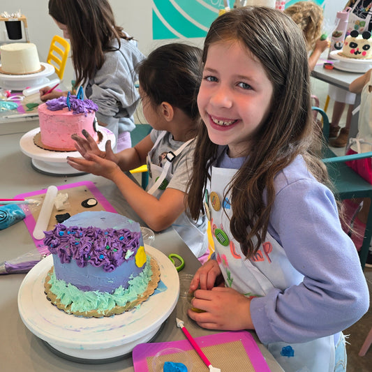 Kids decorate their custom cakes designed during cake camp at Cake Hoopla in Tigard near Portland.