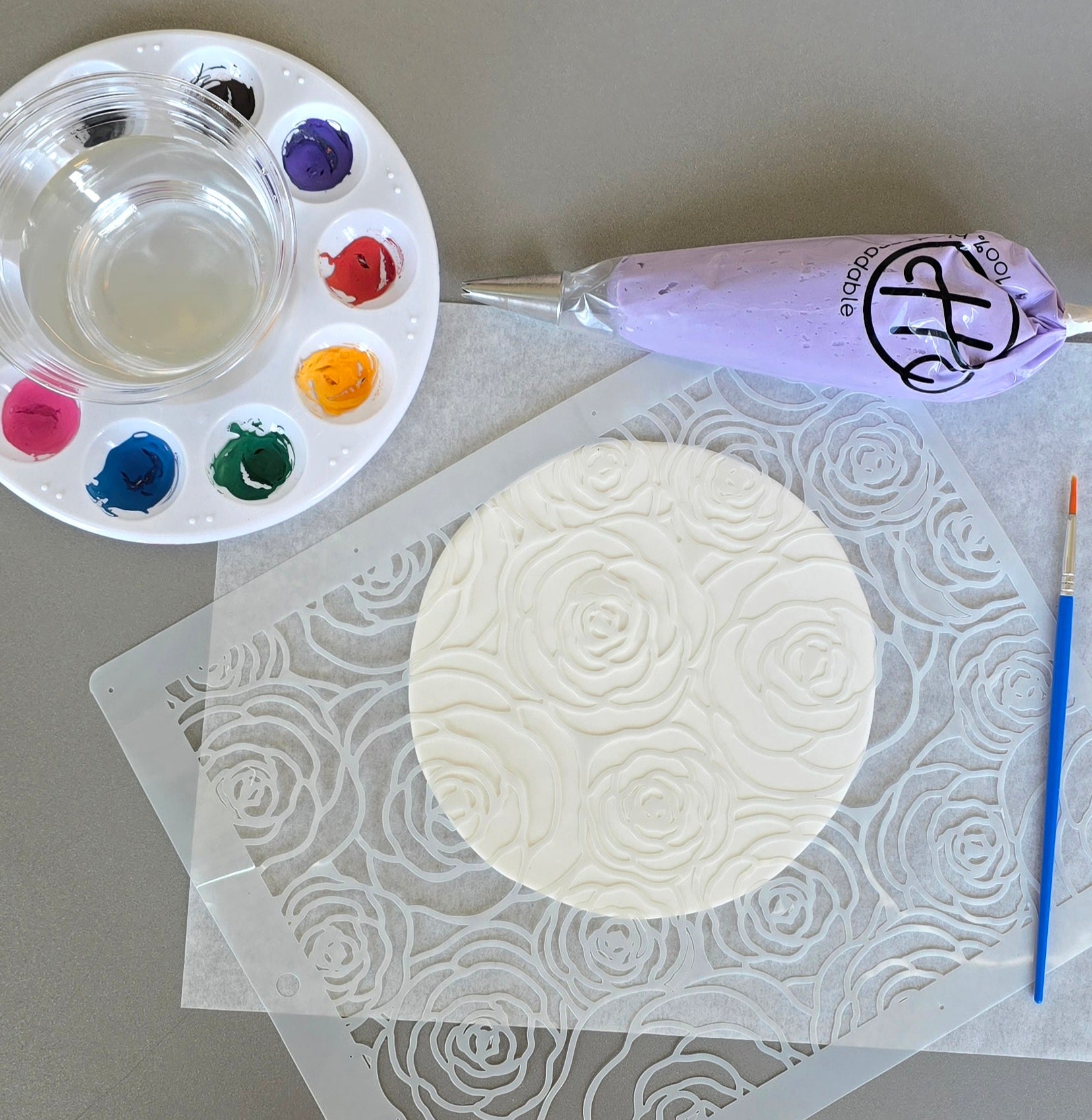 Edible paints, circle canvas, and purple frosting for painting a cake at Cake Hoopla.