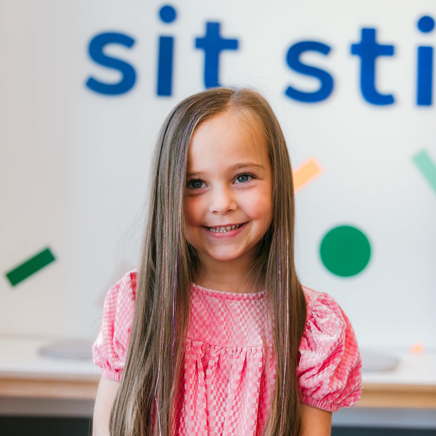 A girl with long hair shows off several sparkle strands by Sit Still Salon in Portland.