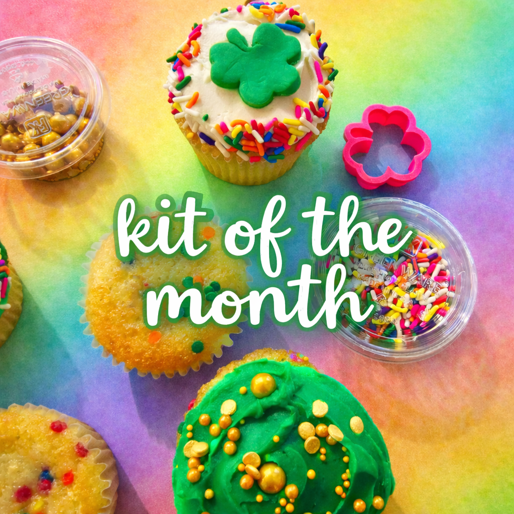 Colorful cupcakes with rainbow sprinkles and a shamrock on a rainbow gradient background, with text 'kit of the month'.