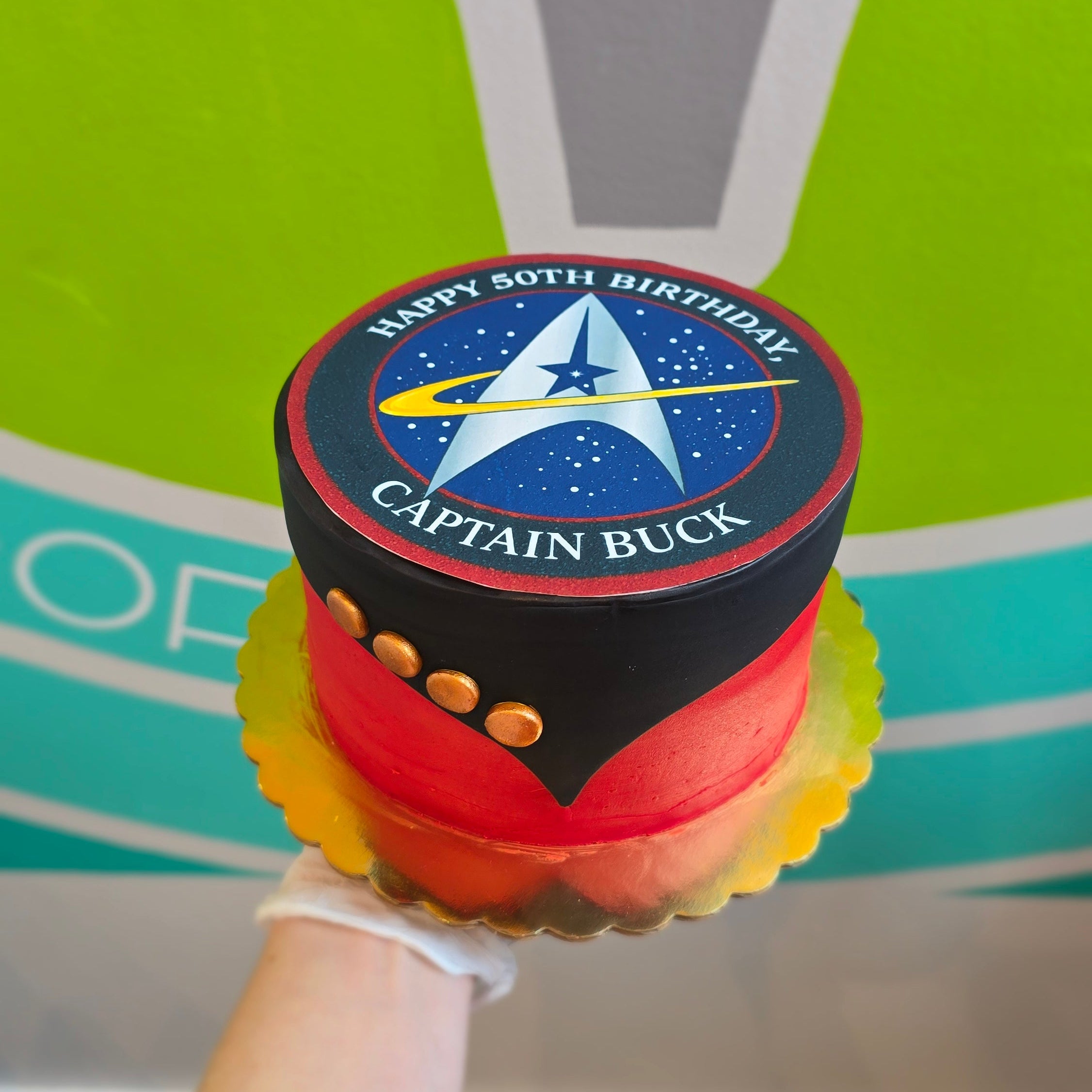 Star Trek birthday cake , red and black, with logo and collar with captain's pips.