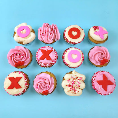 Love-themed XOXO cupcakes frosted pink and white with Xs and Os, hearts, and heart sprinkles; pre-decorated cupcakes available for pick up at Cake Hoopla in Tigard, Oregon, in the Portland area.