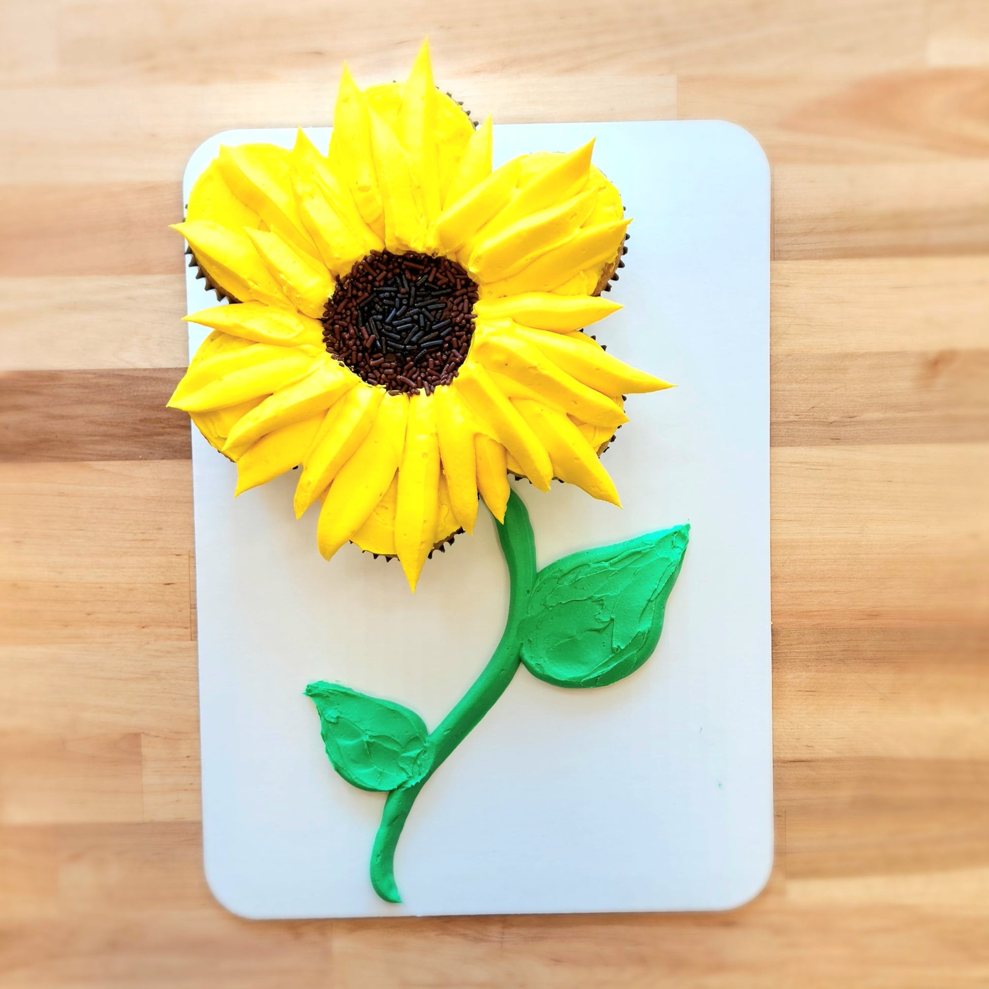 A bright yellow sunflower pull-apart cupcake cake made with 7 cupcakes; the design for a fall-themed cupcake-decorating class at Cake Hoopla on September 21, 2024.