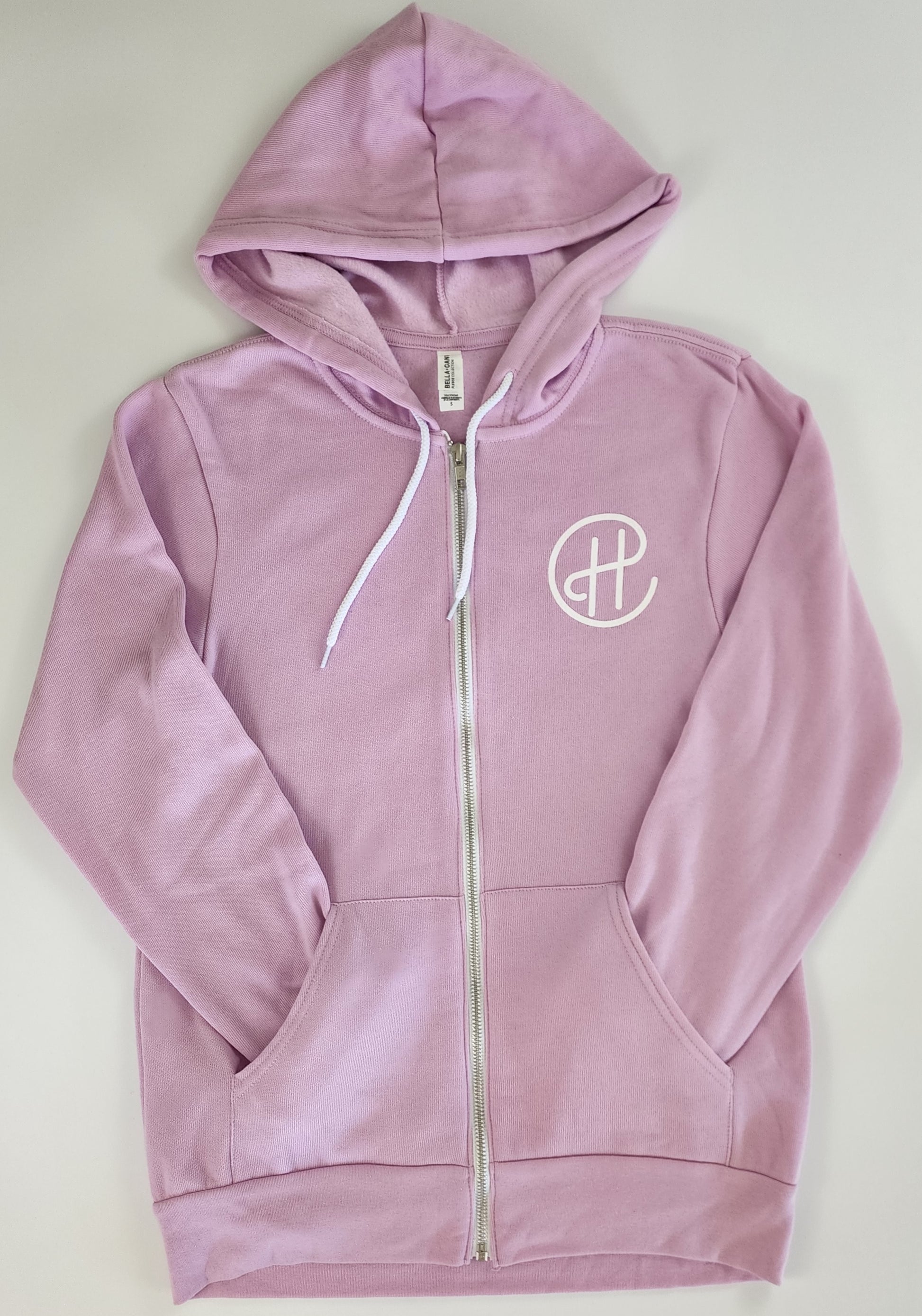 The front of a unisex light-purple zip-up hoodie. Over the left breast in white screen printing are the letters "CH" written in a swirly way, where the bar portion of the H extends up to connect with the C, which encircles the H.