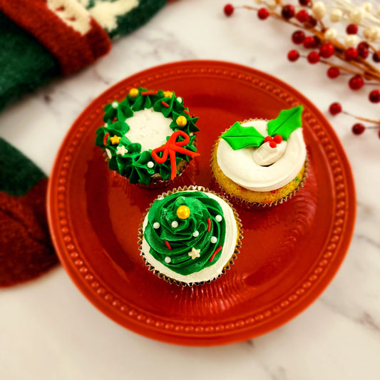 Christmas DIY cupcake decorating. Cupcakes decorated in green and red, frosting wreaths and Christmas trees, and fondant holly leaves.